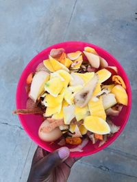 High angle view of hand holding fruits in bowl