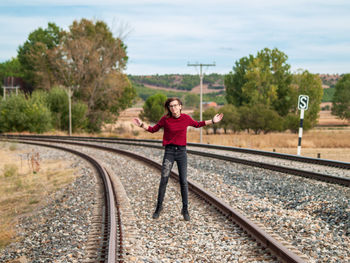 Full length of woman on railroad tracks against sky