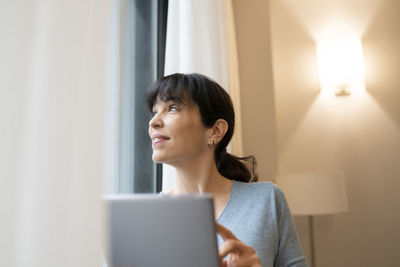 Mid adult woman using mobile phone at home