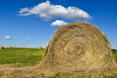 Hay bales on field against sky