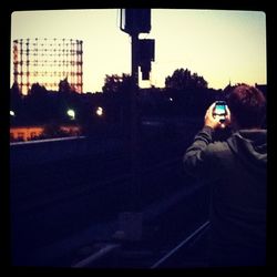 Woman standing in city at sunset