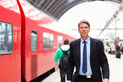 Portrait of man standing at railroad station