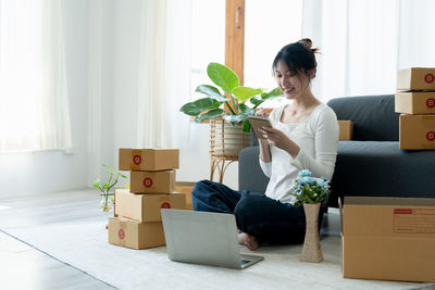 Young woman using laptop while sitting on sofa at home