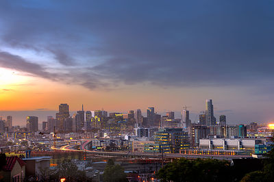 Modern buildings in city against sky during sunset