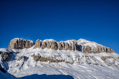 Scenic view of snowcapped mountains against clear blue sky