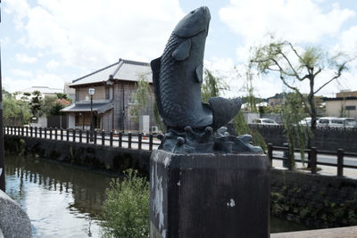 Statue in front of footbridge in city