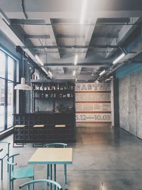 Empty chairs and tables in illuminated building