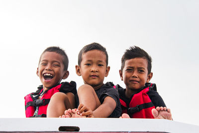 Portrait of smiling boy against clear sky