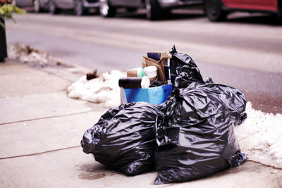 Garbage bin on sidewalk in city