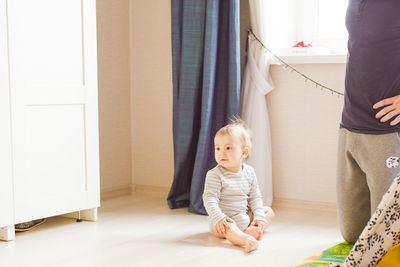 Mother and daughter standing on floor at home