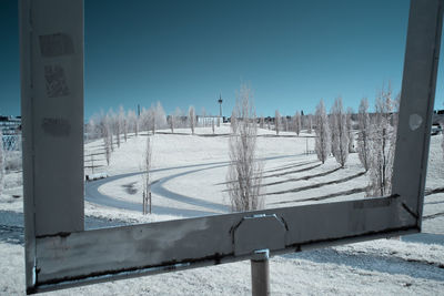 Snow covered field against clear blue sky