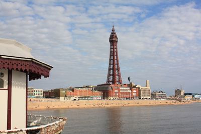 Tower by sea against sky in city