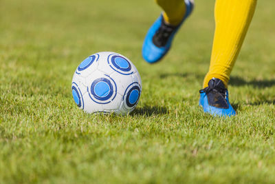 Low section of person playing soccer on field