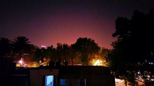 Silhouette trees against sky at night