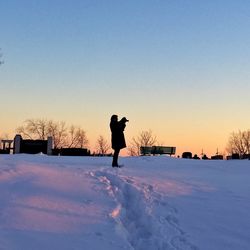 Silhouette of person standing on snow covered landscape