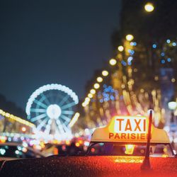 Close-up of taxi sign at night
