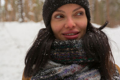 Close-up of woman looking away while standing outdoors during winter