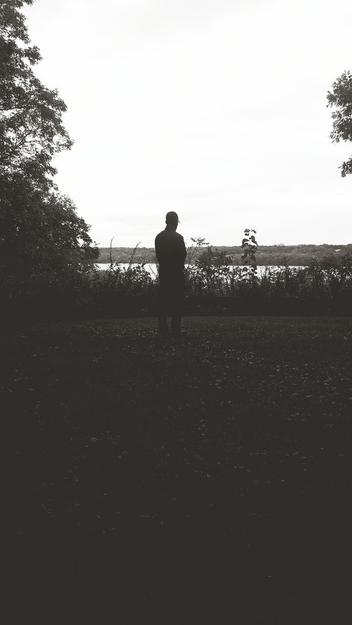 clear sky, silhouette, standing, field, tranquil scene, tranquility, solitude, remote, scenics, day, nature, sky, outdoors, in front of, beauty in nature, alone