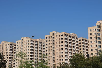 Low angle view of buildings against clear blue sky