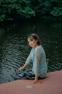 Side view of girl sitting in lake