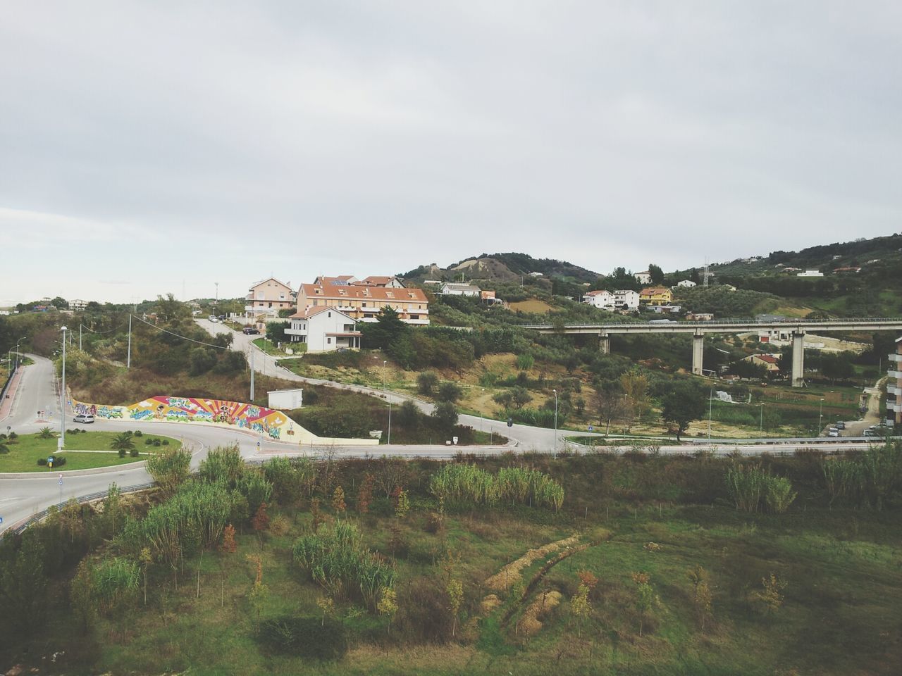 architecture, built structure, building exterior, sky, house, tree, mountain, residential structure, water, cloud - sky, grass, residential building, day, cloud, river, nature, town, outdoors, landscape, plant