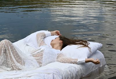 Young woman lying down in lake