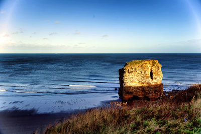 A broken-off section of cliff forms an island in the north sea at south shields, england