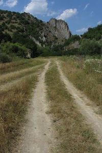 Road amidst field against sky