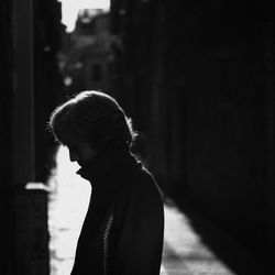 Side view of young man looking away in city