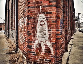 Portrait of man standing against brick wall in winter