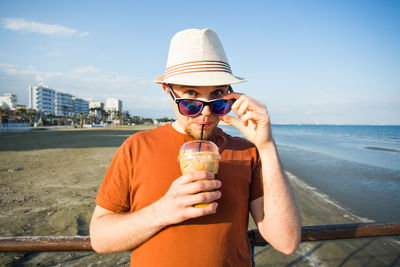 Portrait of man drinking water from beach