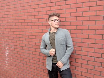 Man standing against brick wall