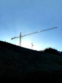 Low angle view of landscape against clear blue sky