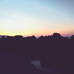 Scenic view of silhouette mountains against sky at sunset