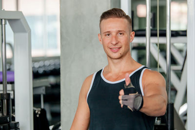 Portrait of man gesturing while standing in gym