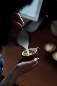 Cropped image of woman preparing coffee at cafe