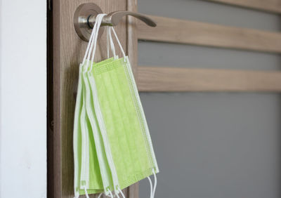 Close-up of clothespins hanging on rope against wall