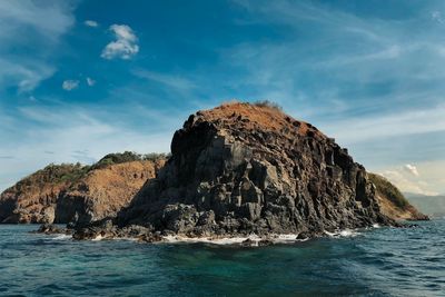 Rock formations in sea against sky