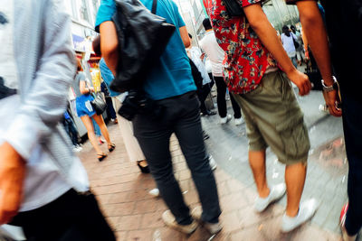 Low section of people walking on footpath at railroad station