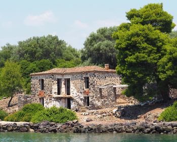 Built structure by lake against sky