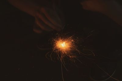 Close-up of hand holding sparkler at night