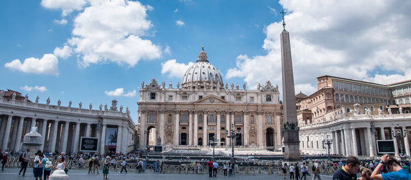 People in front of historic building against sky