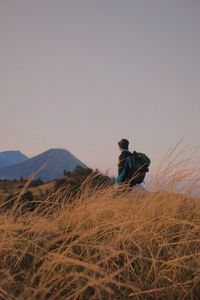 Side view of man on field against sky