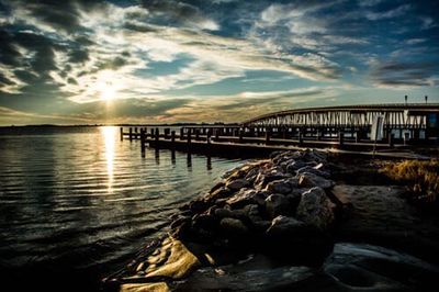 Pier on sea at sunset