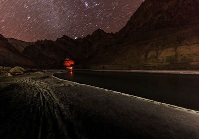 Road by mountains against sky at night