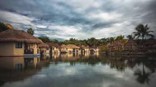 Houses and trees by buildings against sky