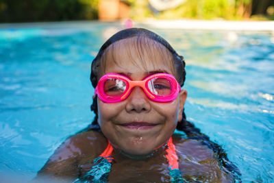 Girl in goggles enjoy training swim at pool in summer camp. active vacation and happy summertime