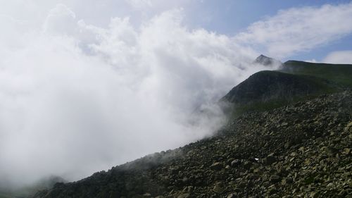 Scenic view of mountains against cloudy sky