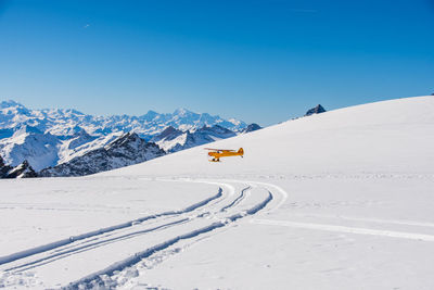 Scenic view of snowcapped mountains against clear blue sky