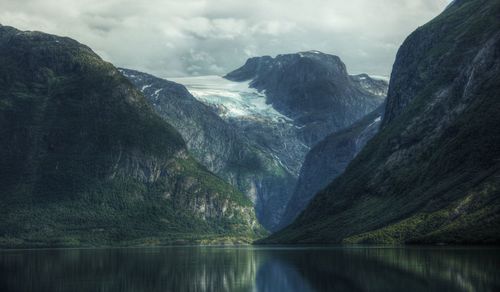 Scenic view of lake by mountains against sky